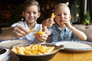 medium-shot-smiley-boys-eating-fries.jpg